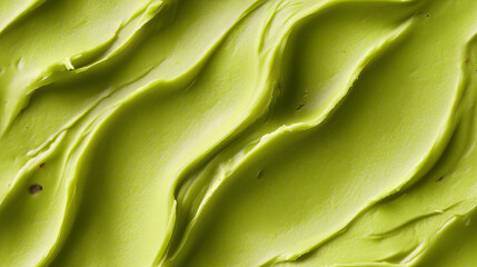 a close-up, top-down view of pistachio paste spread across the frame, filling the image with its vibrant green color and silky texture