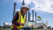© APchanel - Engineers wear safety gear inspecting or document related to plants environment features large industrial chimneys related energy industrial work and environmental monitor carbon credit concept.