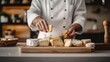 © Luxetify - A chef arranges a selection of different types of cheeses on a wooden cutting board.