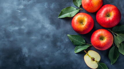 Juicy Red Apples: A tantalizing flat lay showcasing four vibrant red apples with lush green leaves, artfully arranged on a dark slate background. The image offers a half-sliced apple.