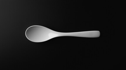 Poster - White ceramic spoon lying on a black background