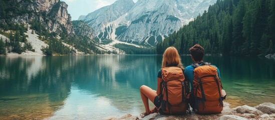 Wall Mural - a couple sits by a beautiful mountain lake, enjoying the view.