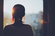 © beeboys - 窓から夕日を見る女性のシルエット