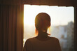 © beeboys - 窓から夕日を見る女性のシルエット
