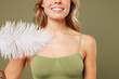 © ViDi Studio - Close up cropped young lady woman with slim skinny body perfect skin she wear top bra lingerie stand hold feather touch neck breast isolated on plain green background. Lifestyle diet fit spa concept.