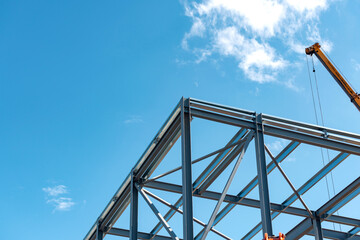 Construction progress on modern steel structure under  bright blue sky in mid-afternoon light