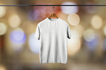 Canvas Print - Empty white t-shirt hanging on blurry light bokeh background. Mock up place. Fashion and showroom concept. 3D Rendering.