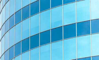 A blue building with many windows and a cloudy sky in the background