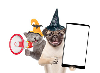 Poster - Happy cat and Pug puppy wearing  hats for halloween looks at camera. Dog shows smartphone with white blank screen in it paw. Kitten meowing into the megaphone. Empty space.isolated on white background