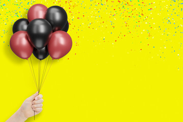Aufkleber - Female hand holds bunch of red and black balloons on yellow background with confetti. Empty space for text