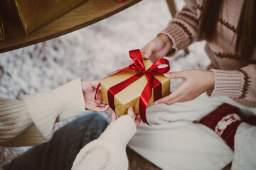 hands giving birthday present gift at home