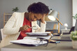 © Studio Romantic - Focused African-American woman uses a magnifying glass to check documents and look for an error in the accounts. Accountant prepares for an analytical and statistical report while sitting in office