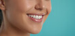 © pecherskiydotkz - close-up profile shot of a young woman’s bright smile, showcasing her white teeth against a smooth, turquoise background, emphasizing dental hygiene and oral health
