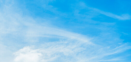 the sky is clear blue with fluffy white clouds, the sky is very bright, and the sun shines.