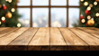 © reddish - A wooden table in front of a festive window with Christmas lights and decorations