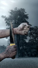 A zombie hand with a bloody wound holding the bloody knife with midnight background. A zombie hand swings the knife to the wrist, creating a tense and scary atmosphere