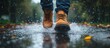 © GoDress - Close-up of a person's feet walking through a puddle in the rain, splashing water.