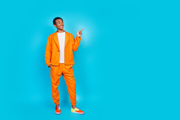 Canvas Print - Photo of attractive guy standing point finger empty space wear trend orange suit isolated cyan color background