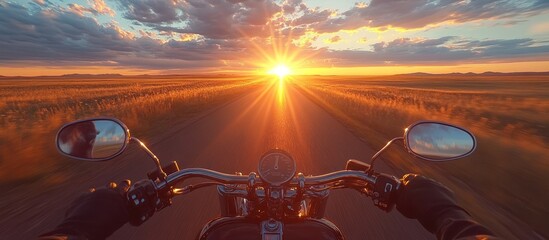 Poster - A motorcycle rider drives into the sunset on a long and empty road with golden fields on either side.