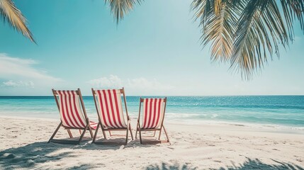 Poster - Two red and white striped beach chairs on sandy beach with palm trees, blue sky, and clear sea, seaside summer vacation. Copy space 