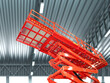 © Grispb - Scissor hydraulic lift. Equipment for construction. Scissor lift inside hangar. Basket for builders at heights. Red hydraulic lift in industrial building. Equipment for high-altitude work.