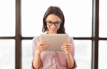 Poster - Business App. Young Woman In Glasses Using Tablet And Laptop Computer In Office. Free Space For Text
