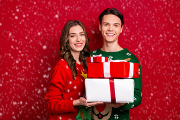 Poster - Portrait of two excited positive people hold pile stack festive giftbox isolated on red color background