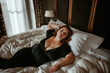 © staras - Sexy plus size curvy model with big breasts lies on bed, fat chubby woman in luxury hotel room