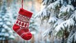 © VisualVault - Red knitted Christmas stocking with Scandinavian decorations hanging in winter landscape