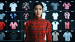 © JackBoiler - fashion designer stands confidently in front of digital display showcasing various clothing styles. vibrant red dress contrasts beautifully with array of shirts behind her, highlighting fusion of