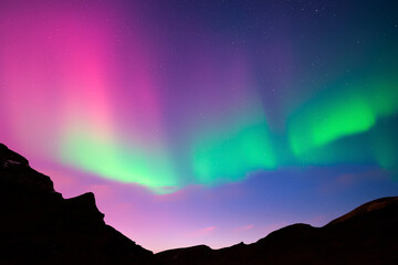 Wall Mural - Night sky with purple Aurora borealis Northern lights in winter mountains. Sky with polar lights and stars with dark hills. Landscape photography