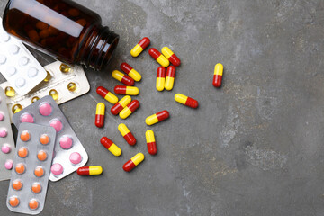 Poster - Pharmacist. Many different pills and overturned bottle on grey table, flat lay. Space for text