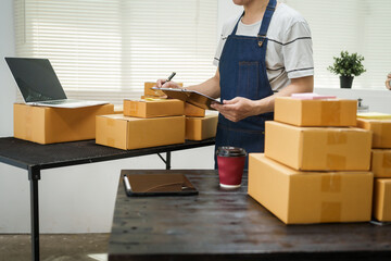 A man is working at his desk, preparing parcel boxes for shipment. He checks and packs items carefully, using shockproof materials, and attaches labels before sending them to customers via EMS.