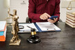 © NanSan - A male lawyer is working at his desk on an online judicial review, focusing on justice, fairness, and legal compliance.He reviews cases, contracts, and legal matters based on general law principles