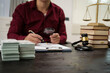 © NanSan - A male lawyer is working at his desk on an online judicial review, focusing on justice, fairness, and legal compliance.He reviews cases, contracts, and legal matters based on general law principles