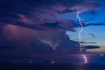 Wall Mural - Dramatic Lightning Storm Over Pacific ocean Sea and far away island mountains before sunrise dawn