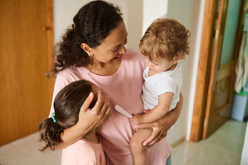 Loving mother bonding with her children at home