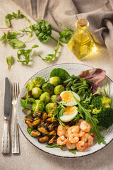 Wall Mural - Shrimp and mussels cooked in coconut oil, served with greens, brussels sprouts, broccoli and eggs. Keto diet.