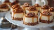 © ifoto - A close-up of Pecan CIDDY cheesecake mini's, each decorated with caramel drizzle and sliced pecans, arranged on an elegant platter for serving at the party