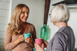 © InsideCreativeHouse - Adult daughter talking with senior mother in kitchen while drinking coffee