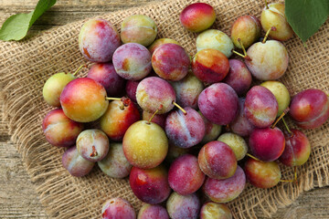 Wall Mural - Tasty ripe plums on table, flat lay