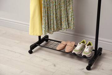 Canvas Print - Rack with clothes and shoes on floor indoors