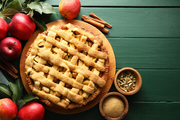 Tasty homemade apple pie and ingredients on green wooden table, flat lay