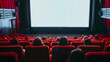 © Alexander - Cinema experience blank wide screen with red chairs and blurred silhouettes of audience in a movie hall