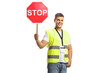 © Ljupco Smokovski - Young man in a reflective safety vest holding a stop traffic sign