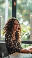 Poster - A woman with curly hair is sitting at a desk with a laptop