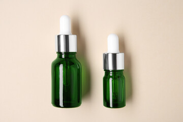 Wall Mural - Essential oils in bottles on beige background, top view