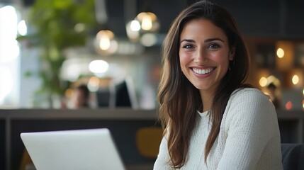 Wall Mural - Happy woman working on laptop in modern office setting