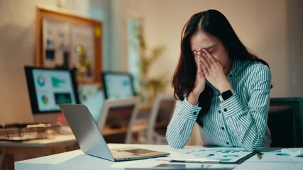 Aufkleber - young asian businesswoman sitting at her desk feels overwhelmed and stressed while working on her la