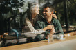 © BGStock72 - Couple enjoying a warm afternoon together in a cozy cafe, sharing smiles and laughter over coffee while seated by a large window